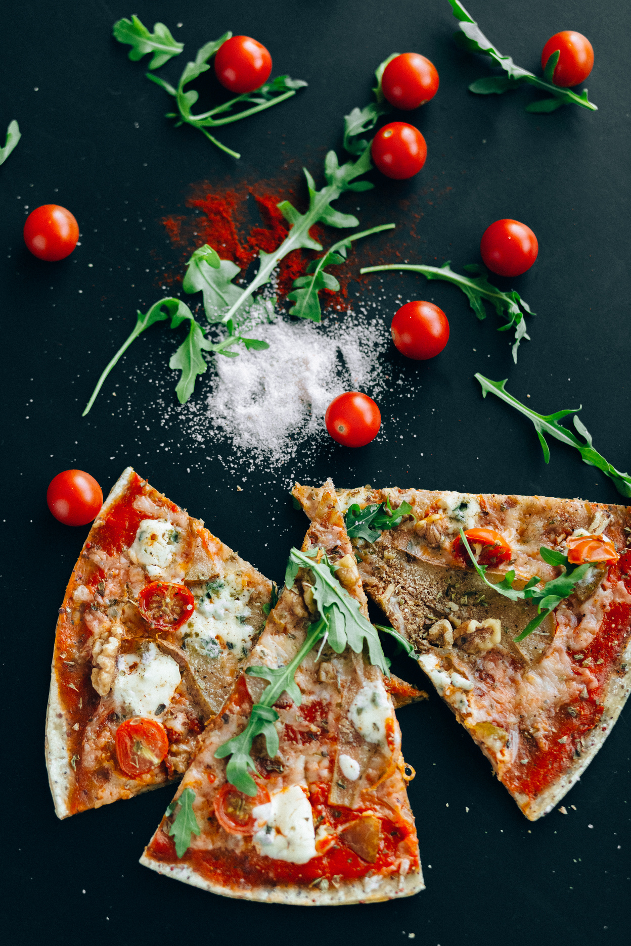 Slices of Pizza, Arugula and Cherry Tomatoes on Flat Surface